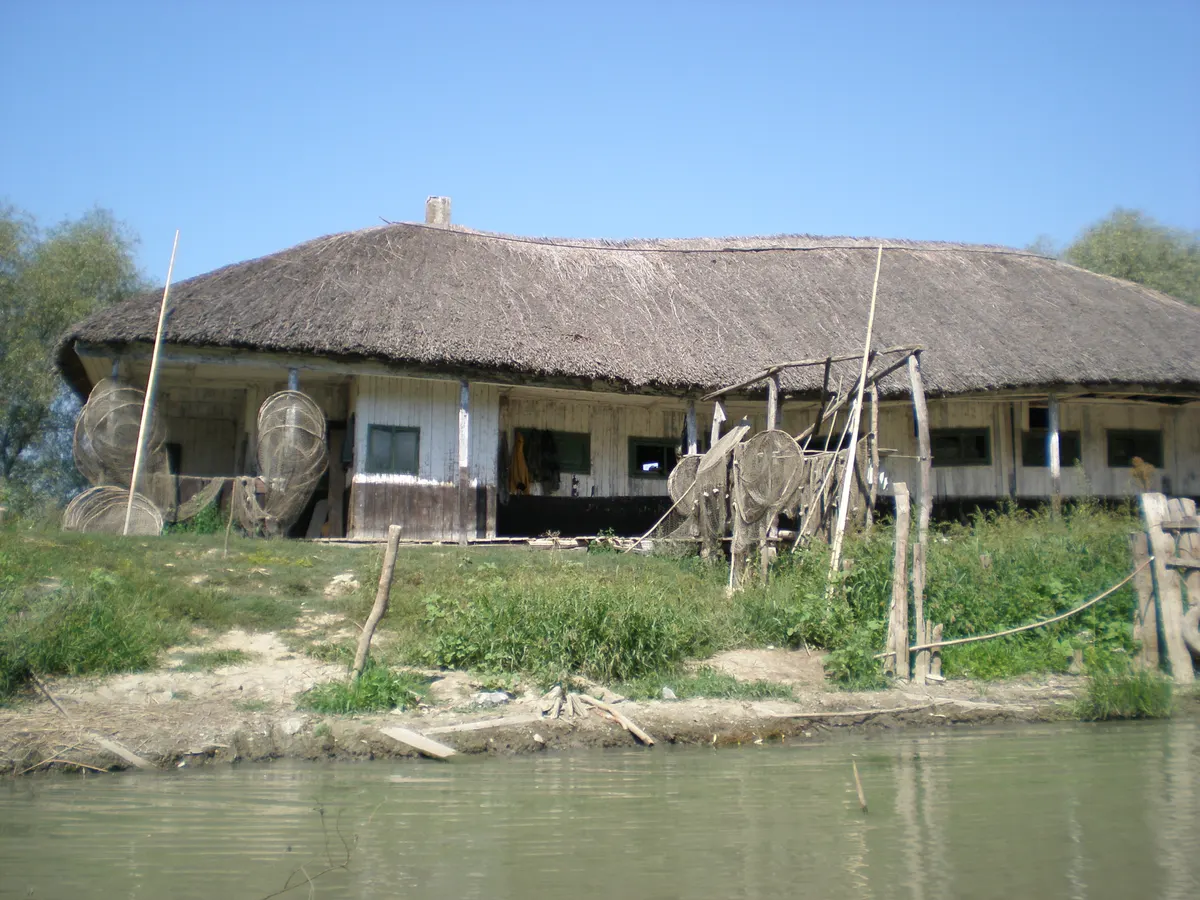 Old reed-roofed house by the water in Caraorman